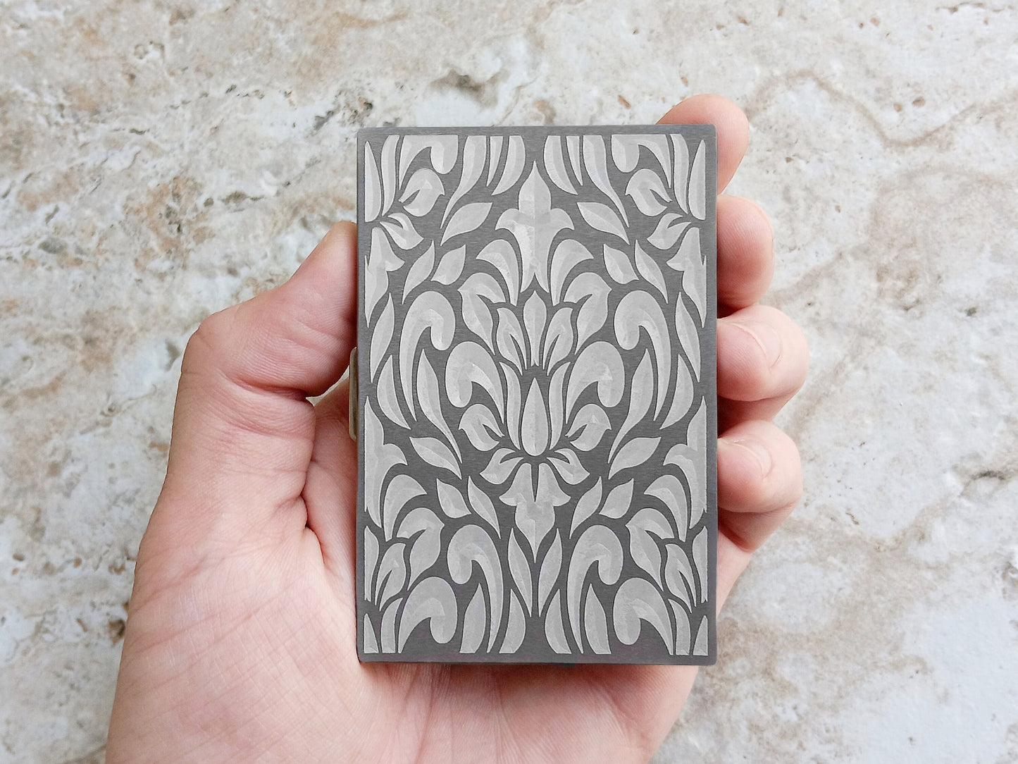 Back Side View of Floral Design on Engraved Stainless Steel Credit Card Case in Hand